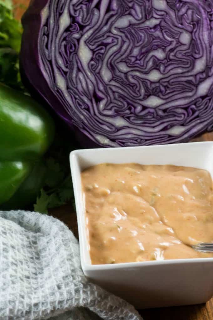 Homemade Thousand Island Dressing in a small square bowl with purple cabbage and green pepper 