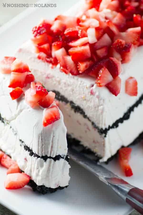 Frozen strawberry easy dessert with a slice cut by a knife on a white plate in 21 Awesome Frozen Desserts