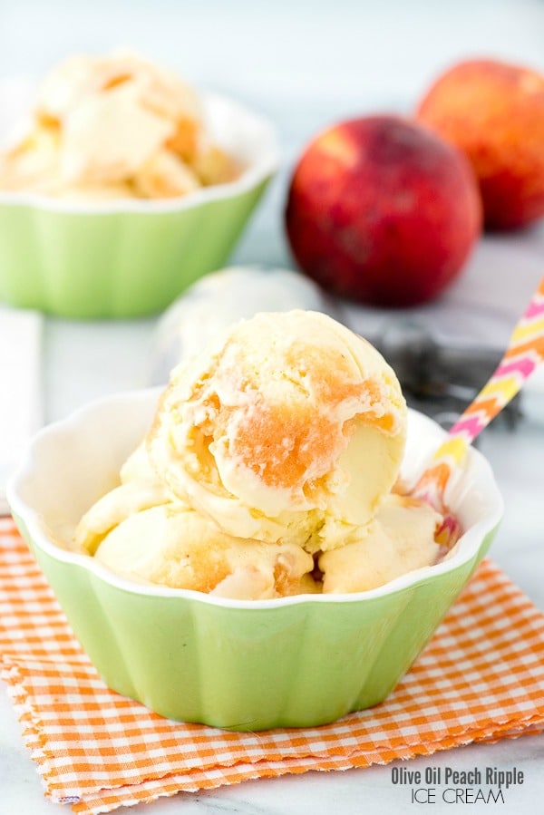 Olive oil ice cream with peach ripple in green bowl with a spoon