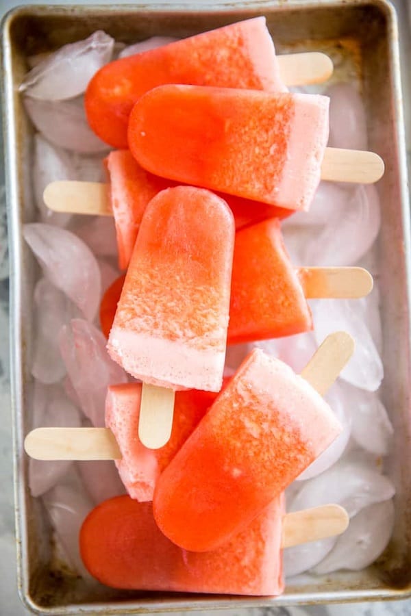 Rum punch popsicles on top of ice cubes in 21 Awesome Frozen Desserts