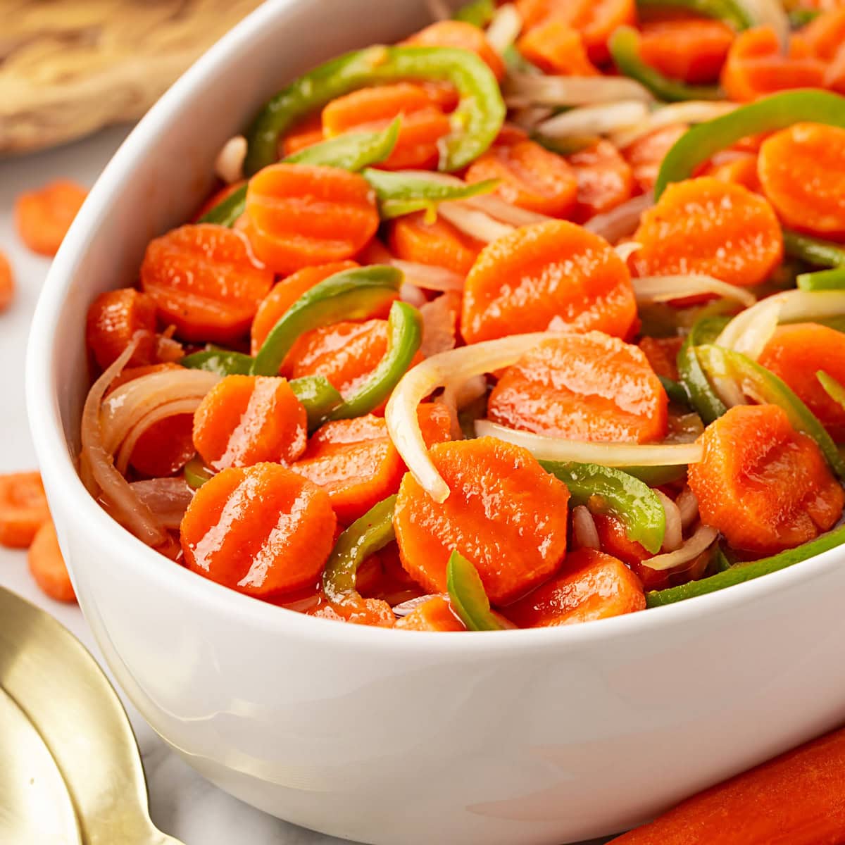 This Marinated Carrot Salad was a staple in our fridge as I grew up. It can be marinated for a long time, so it is perfect to have at the ready for any outing. Close-up of carrot salad in a white dish.