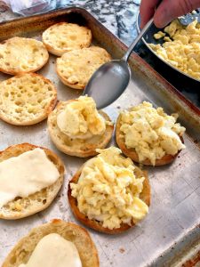 Topping the English Muffins with scrambled eggs