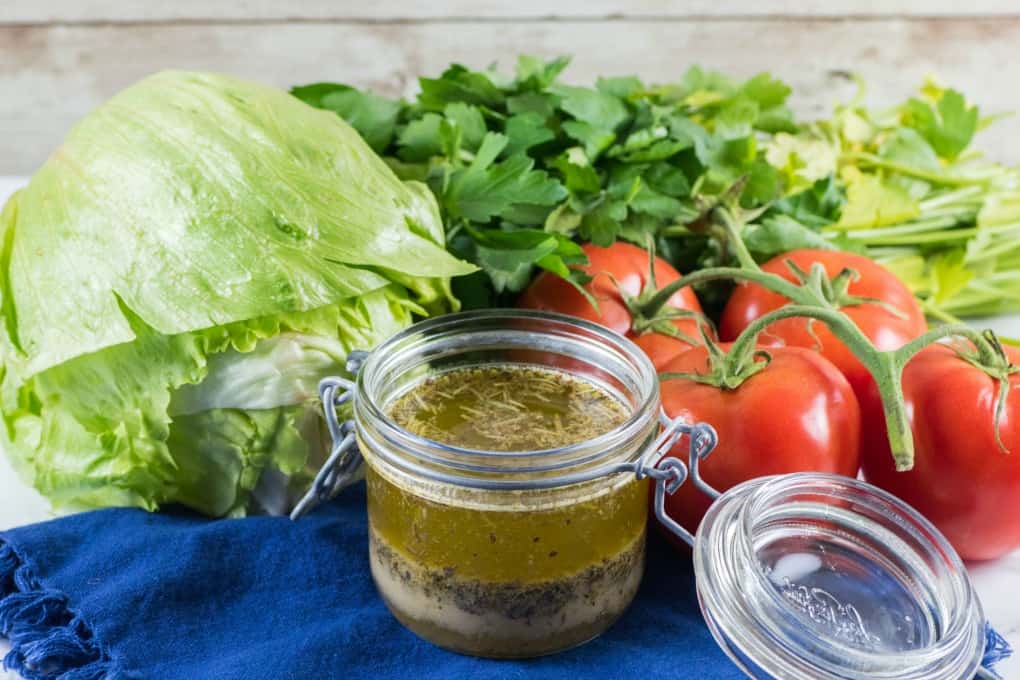 Jar of homemade Italian dressing with fresh veggies