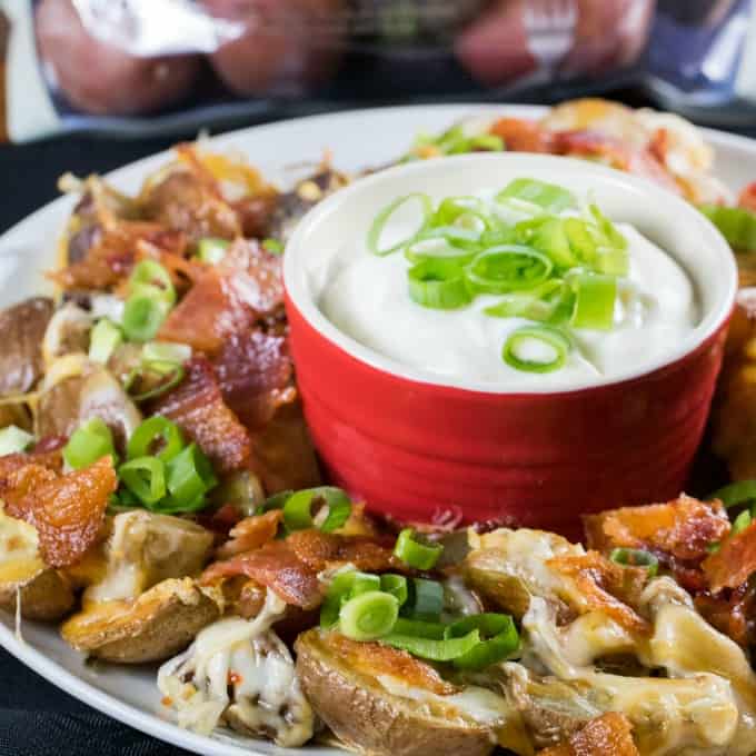 Little Potato Irish Nachos on a white plate with sour cream