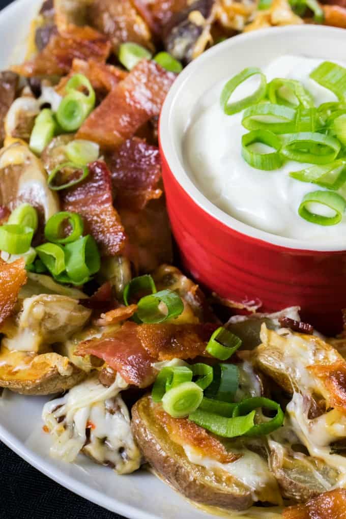 Close up of Little Potato Irish Nachos on a platter with sour cream