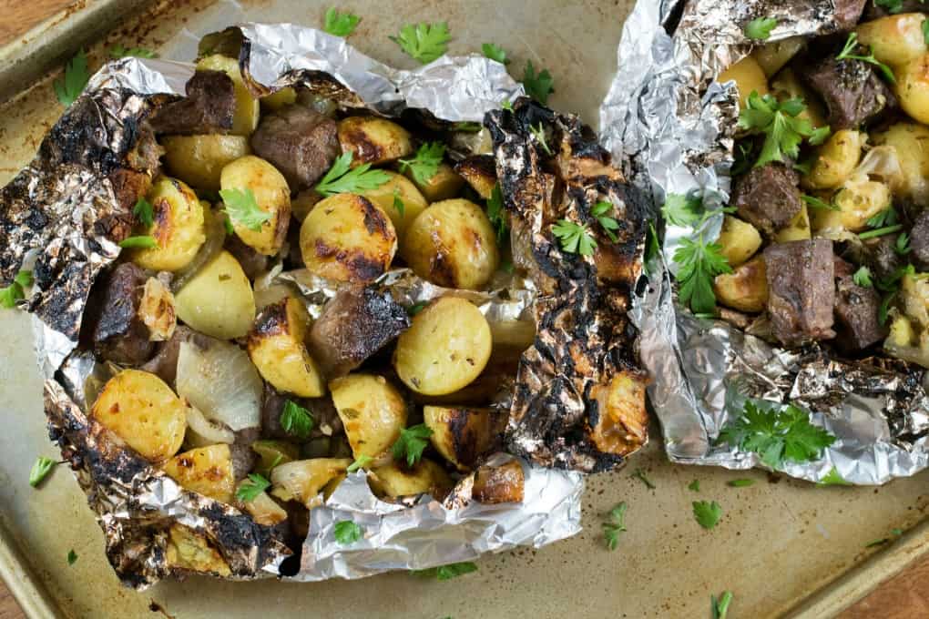 Overheat shot of opened Steak and Little Potato Foil Packs on a baking tray