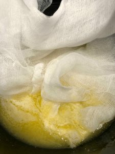 Placing the cheesecloth in butter and wine mixture