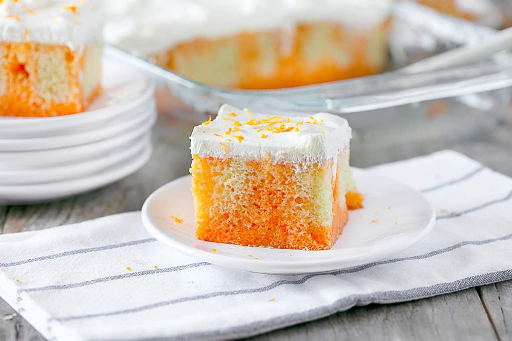 Orange Creamsicle Poke Cake on a white plate