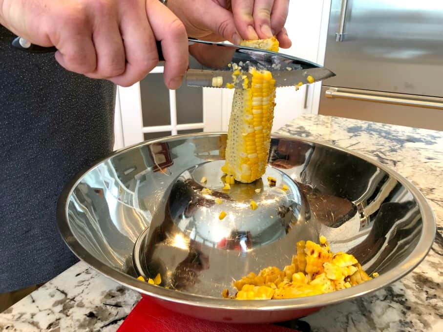 Removing corn off the cob in the inverted bowl method. 