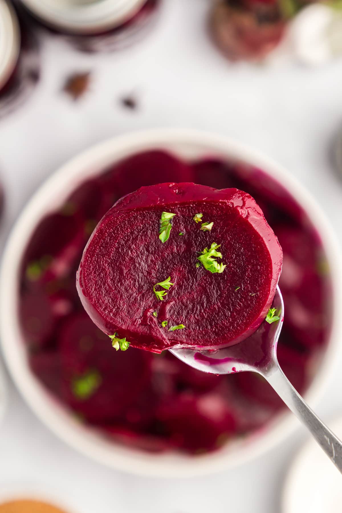 A slice of easy pickled beets recipe with fresh parsley seen up close. 