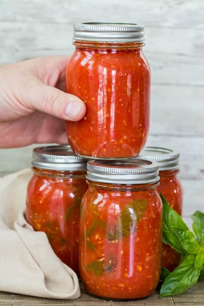 Grabbing jar of Pomodoro sauce from a stacked set of jars