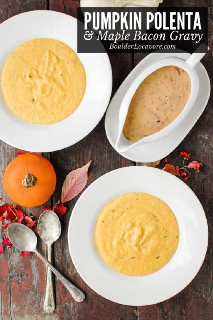 White bowl of pumpkin polenta with a gravy boat of maple bacon gravy on a wooden board with 2 serving spoons