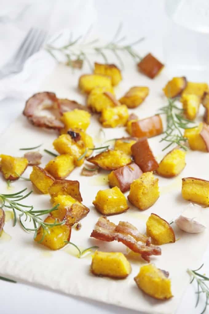Roasted pumpkin with pancetta and rosemary on a white tray