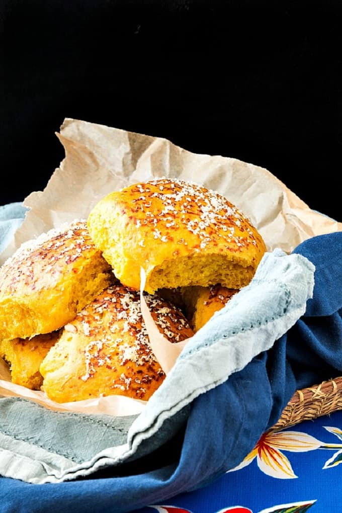 Pumpkin dinner rolls in a paper and cloth lined basket