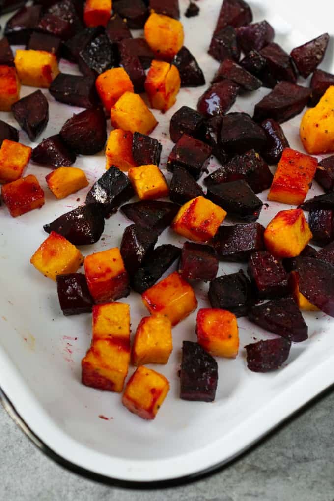 roasted beets and butternut squash in a white baking dish