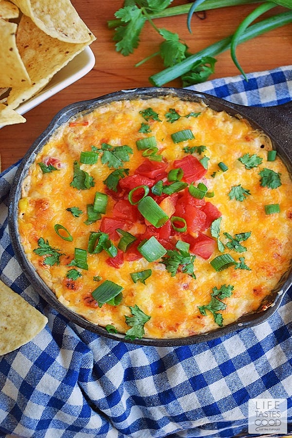 Hot Corn Dip Recipe in a cast iron pan on a checkered blue tea towel from 18 Easy Hot Party Appetizer Recipes