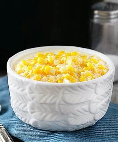 Slow Cooker Creamed Corn. Bowl of creamed corn sitting in front of slow cooker