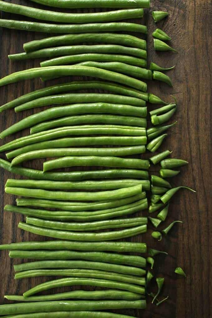 Zesty Green Bean Casserole - Bright green beans in a row with their ends snipped off.