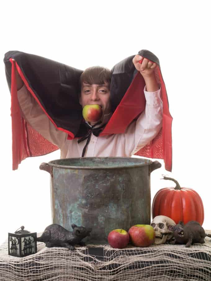 Boy dressed as Dracula bobbing for apples 