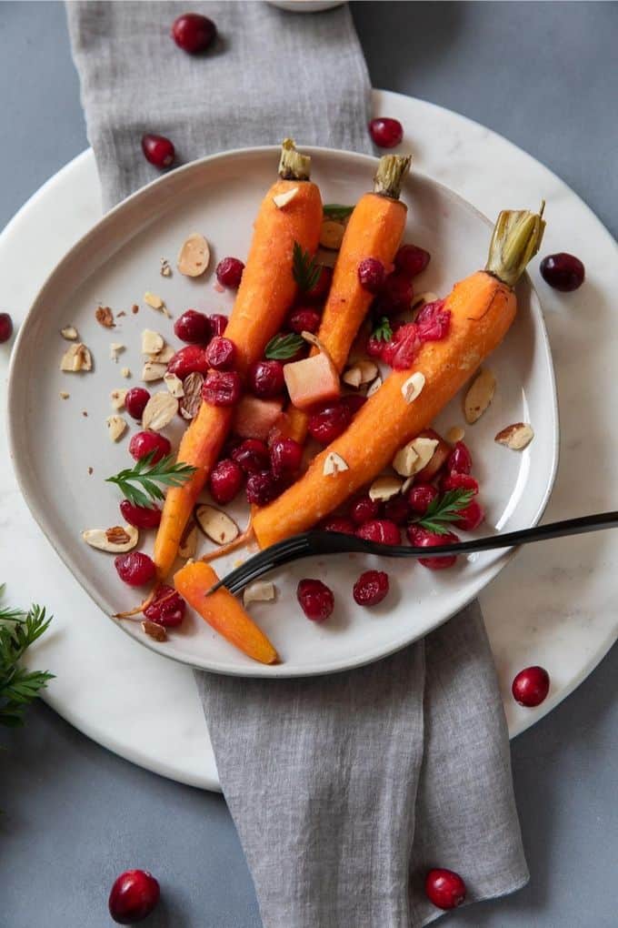 3 carrots on a plate with a black fork