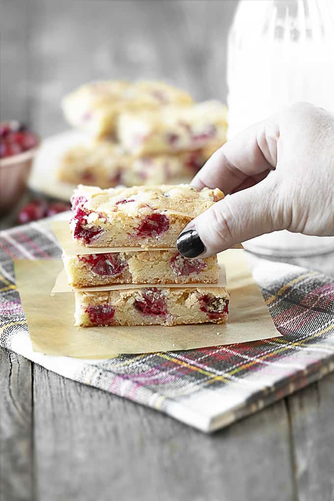 Hand reaching for Lemon Cranberry Bar