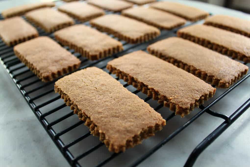 A black backing rack holds twelve brown rectangular cookies in neat rows.