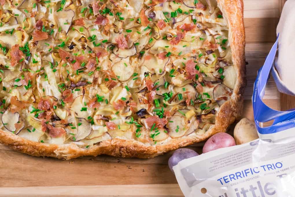 Little Potato Galette on a board with a few potatoes rolling out of a bag