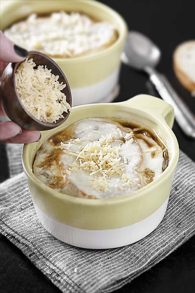 Sprinkling Parmesan Cheese onto French Onion Soup