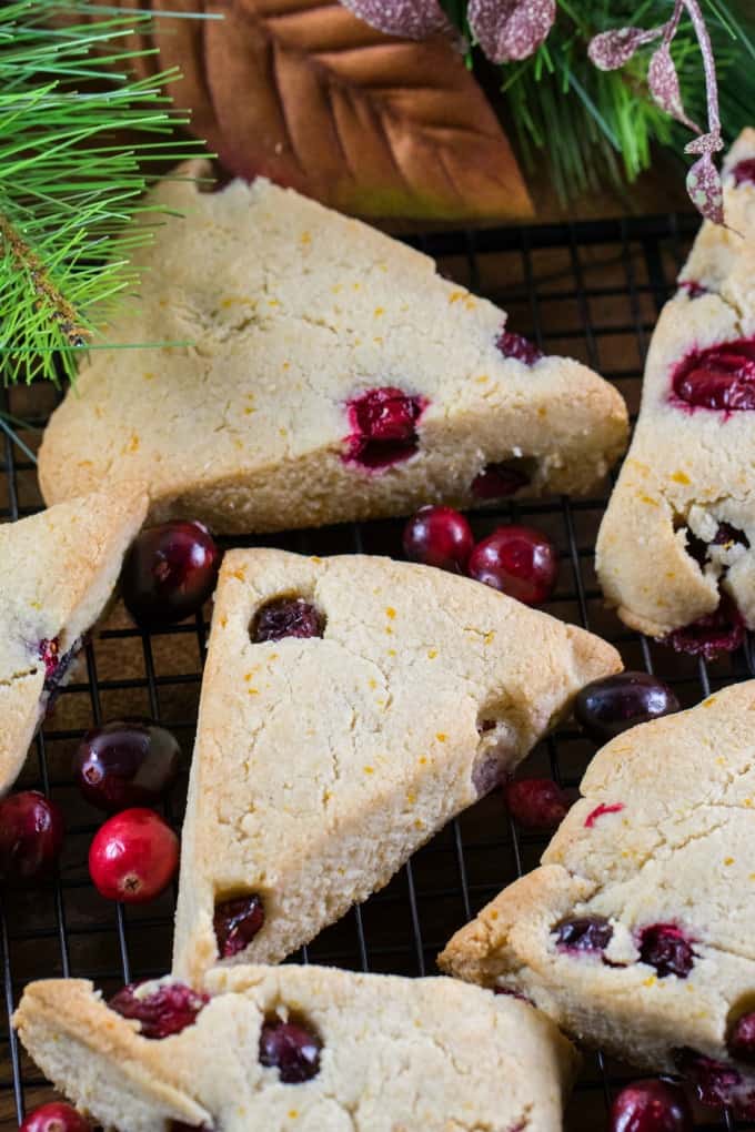 Overhead shot of scones on a black wire rack with fresh cranberries 