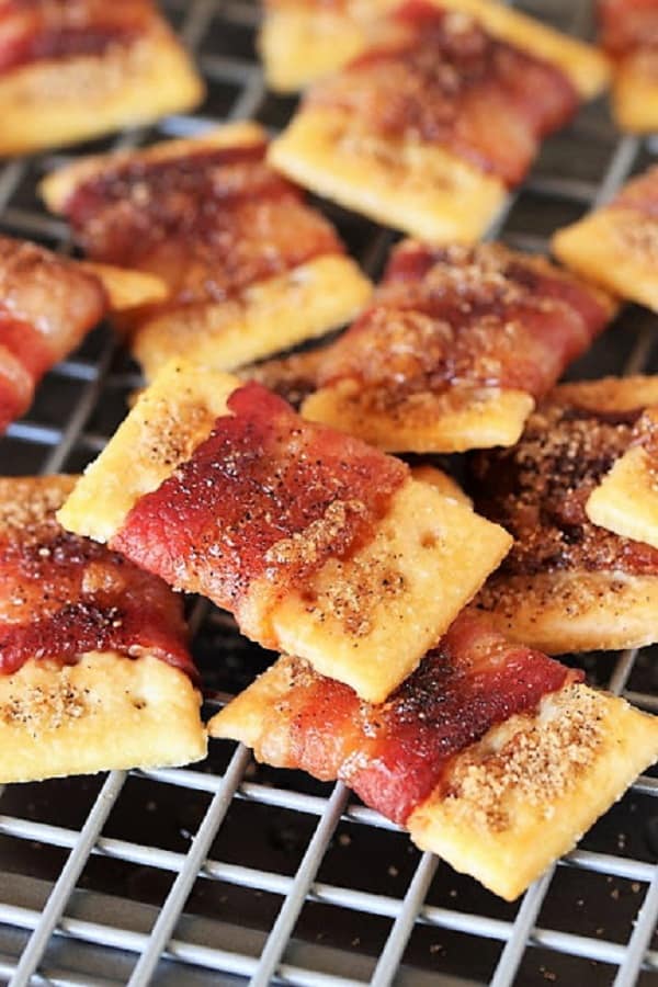 bacon wrapped around a cracker on a wire mesh cooling rack