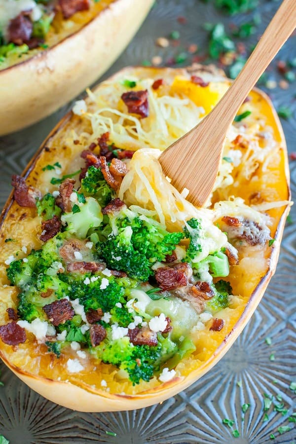 Cheesy bacon broccoli spaghetti squash on a glass tray with a wooden fork