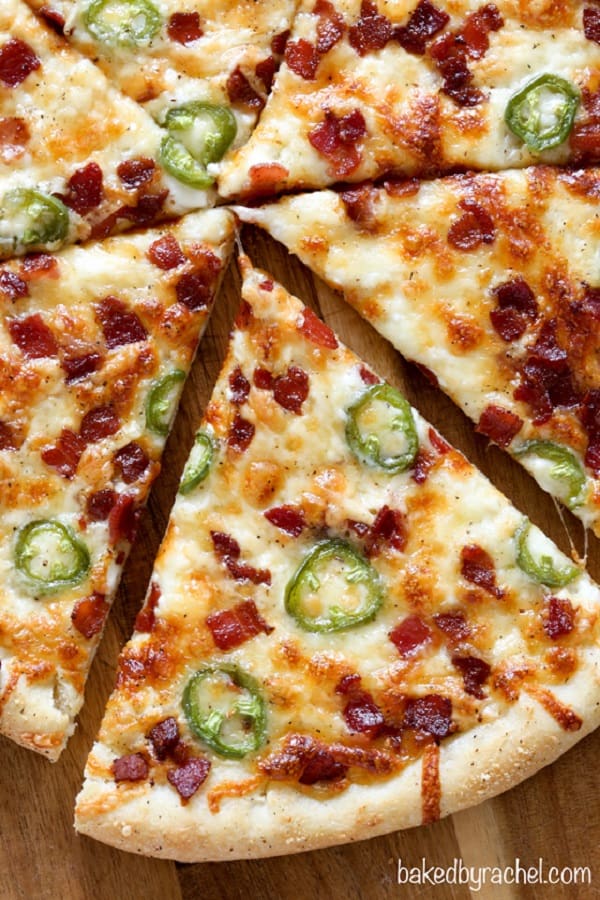 Jalapeno popper pizza sliced on a wooden cutting board