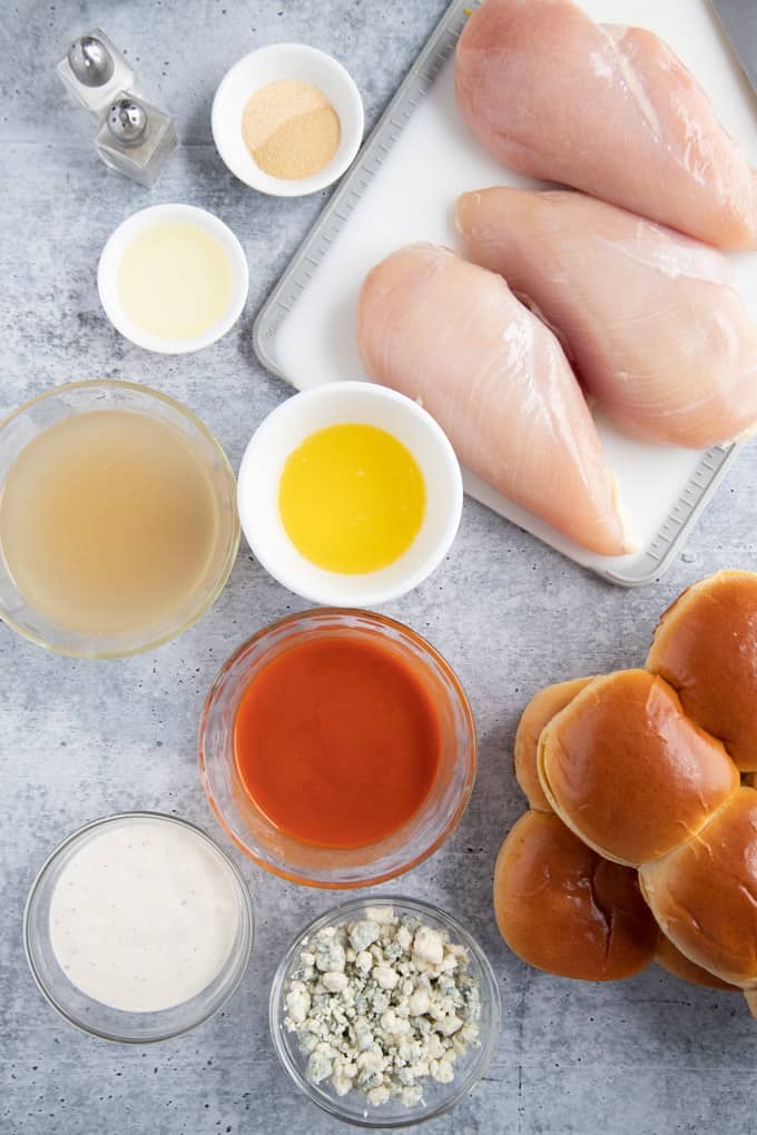 buffalo chicken sliders ingredients laid out on a cement board