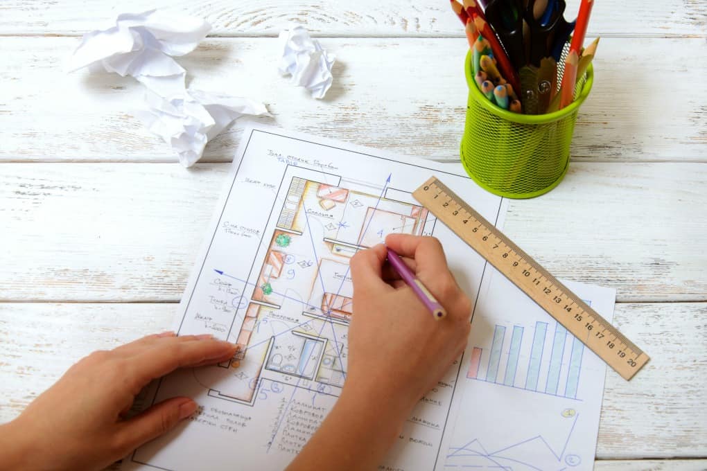 The woman draws a diagram of Feng Shui in the apartment layout. View from the top.