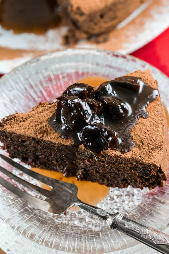 Fudgy Prune Chocolate Cake on a glass plate with a fork. 