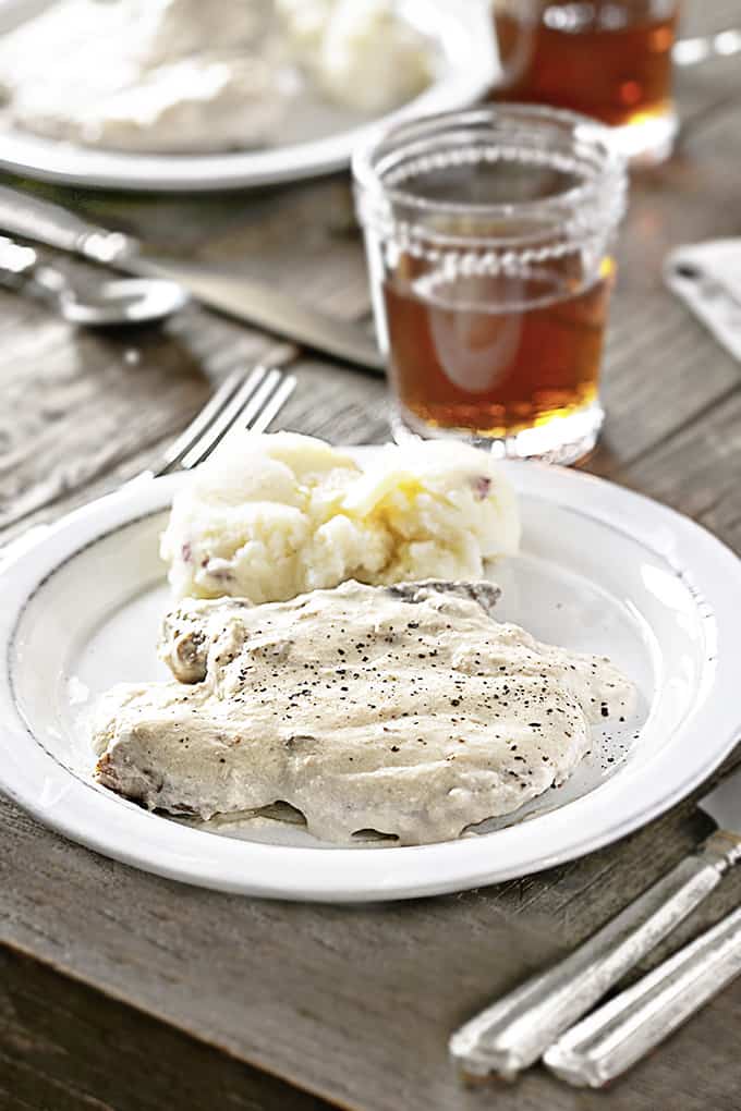 Table setting with Slow Cooker Pork Chops on a white plate with mashed potatoes