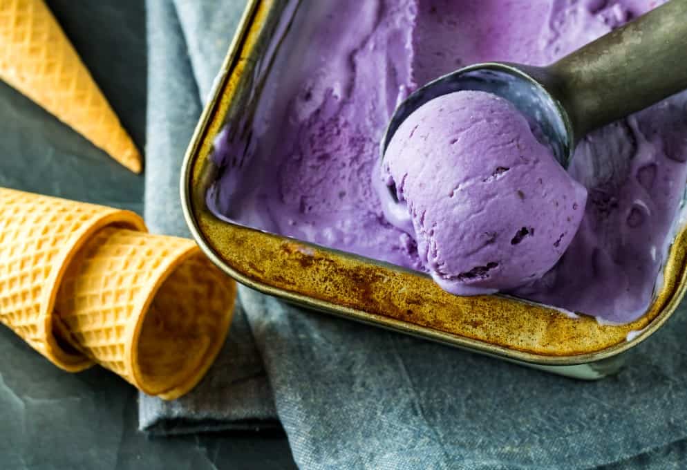Close up view of ice cream cones and a pan of Ube ice cream ready for preparing and eating.