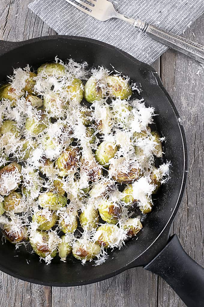 Roasted Brussels Sprouts with Parmesan in a cast iron pan, overhead shot. 