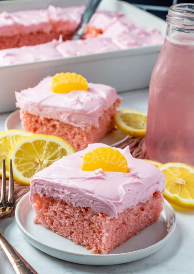 Full picture of cake being served on plates with lemon slices and lemonade