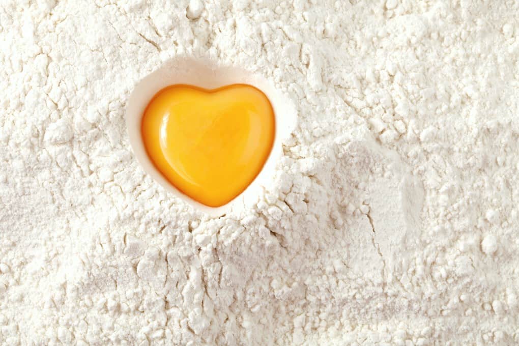 love to bake it! egg yolk on flour, full frame