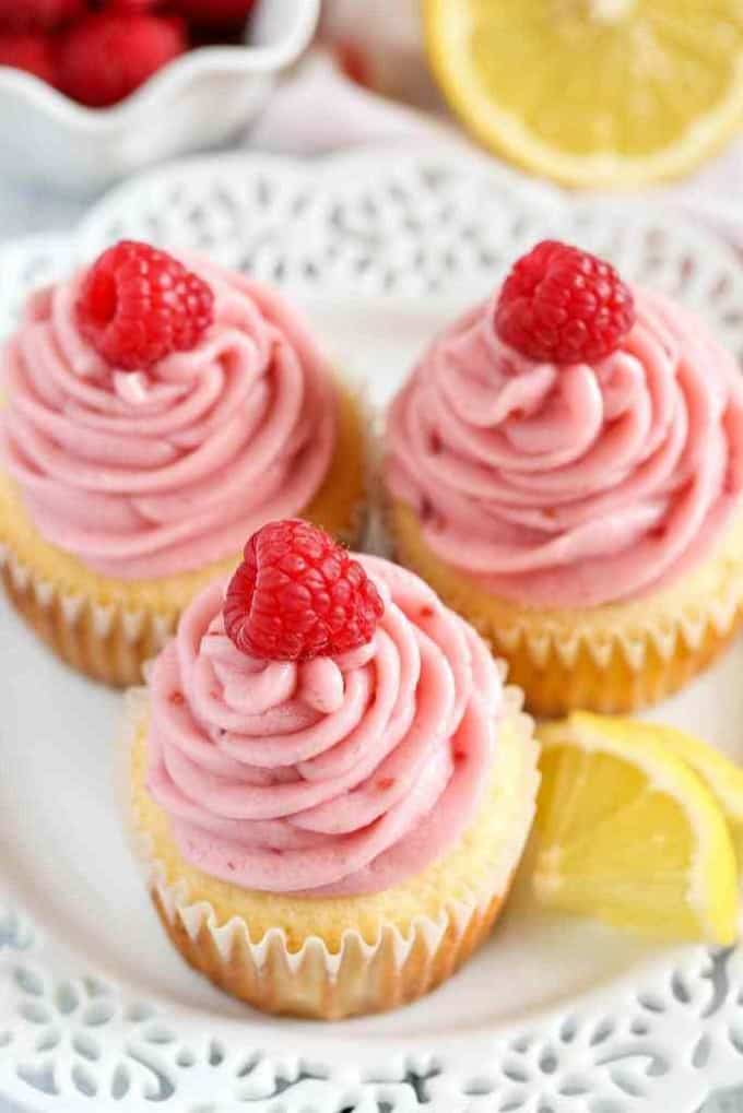 Lemon cupcakes with raspberry frosting on a white plate