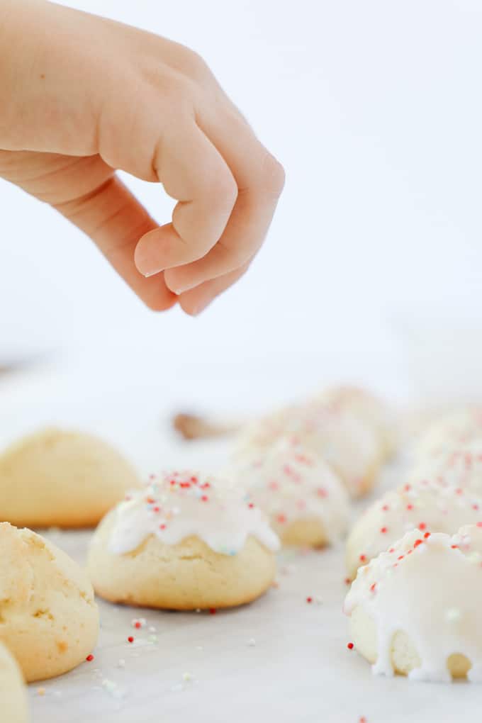 Putting sprinkles on top of a cookie