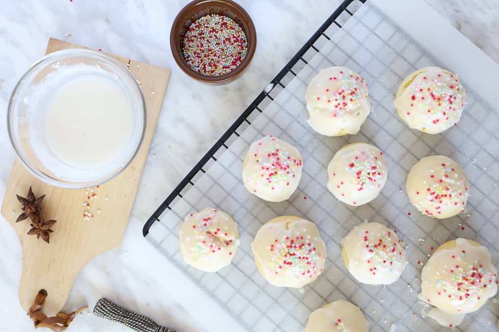 Overhead shot of cookies on a cooling rack with icing and sprinkles. 