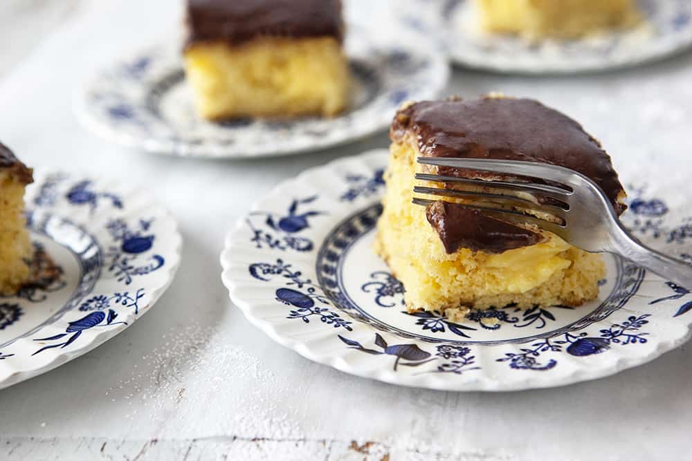 Boston Cream Poke Cake - cutting into slice of cake