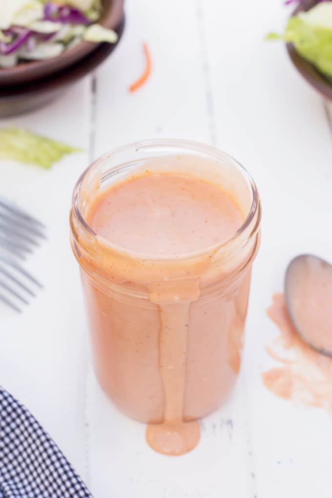 Jar of Russian Dressing with some spilling out the front of the jar.