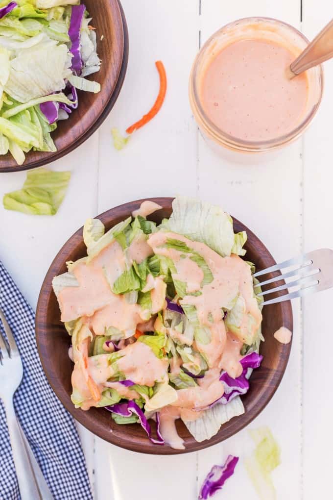 Overhead shot of salad in a bowl with Russian Dressing plus more in a jar.