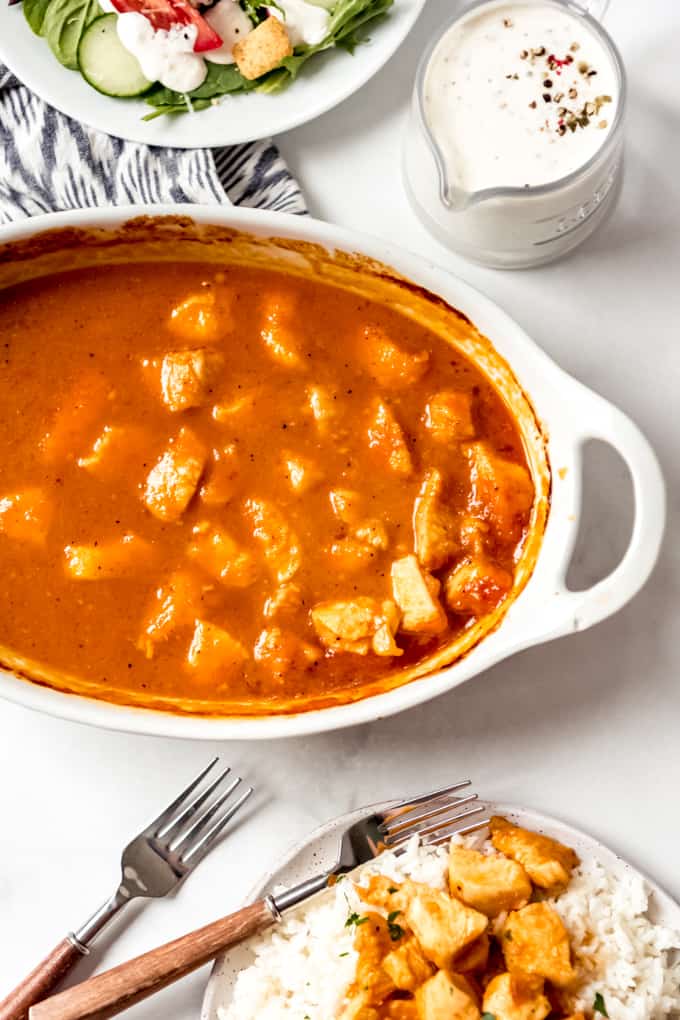 Russian chicken in a casserole with salad in a overhead shot. 