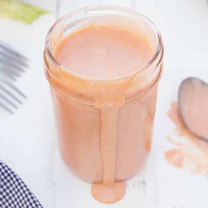 Jar of Russian Dressing with some spilling out the front of the jar.