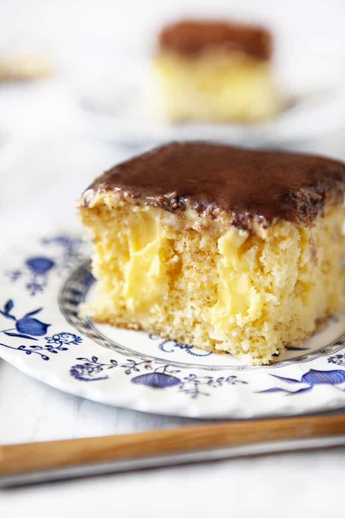 Slice of Boston Cream Poke Cake on antique plate