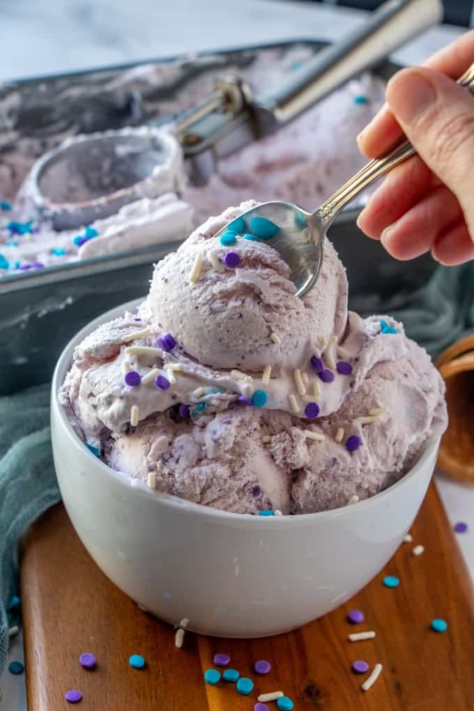 Diving into a bowl of Ube ice cream with a spoon.